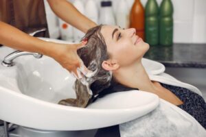 اكتشفي أفضل وصفة لتكثيف الشعر الخفيف وملء الفراغات 5 woman washing head hairsalon 1 scaled 1 607x405 1